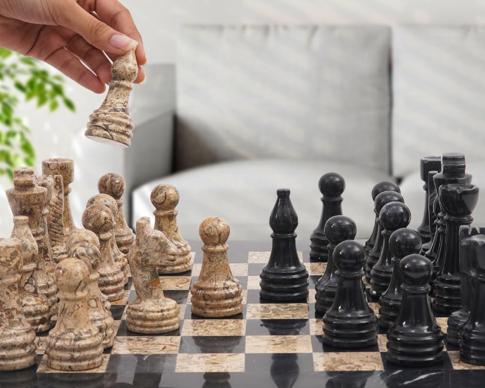 Hand moving a chess piece on a marble chessboard
