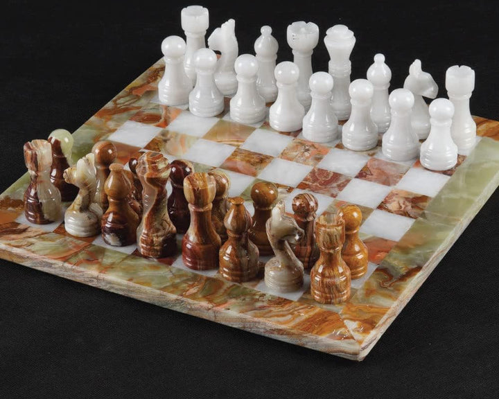 Marble chess set with white and brown pieces on a black background