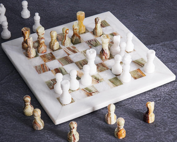 Marble chessboard with chess pieces on a dark surface