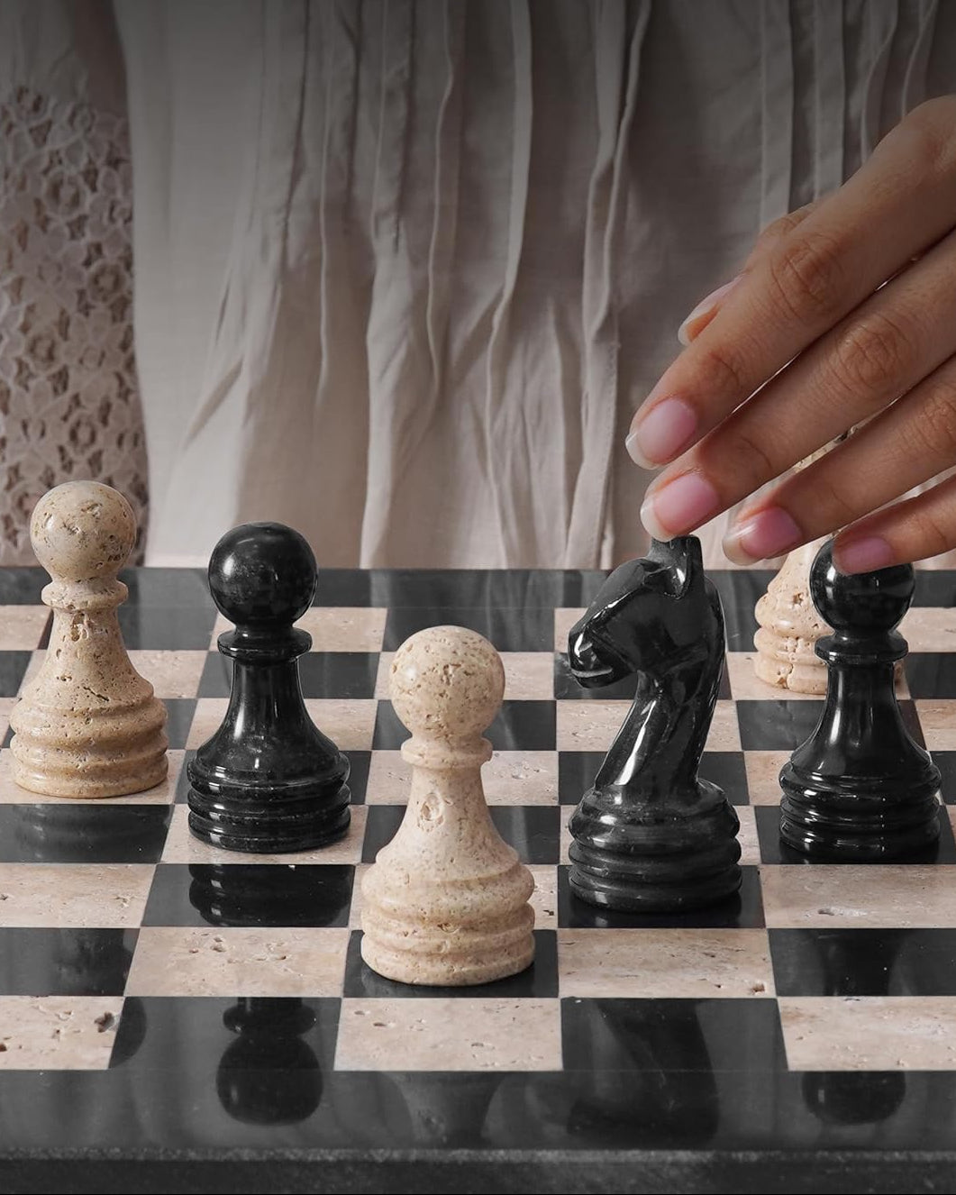 Hand moving a chess piece on a checkered board 