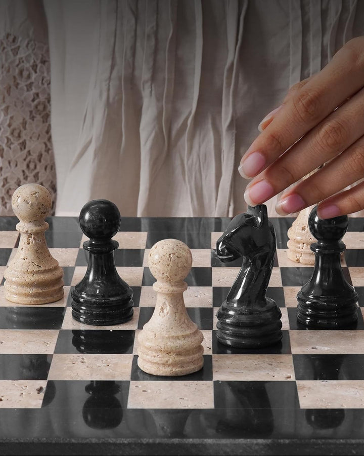 Hand moving a chess piece on a checkered board 