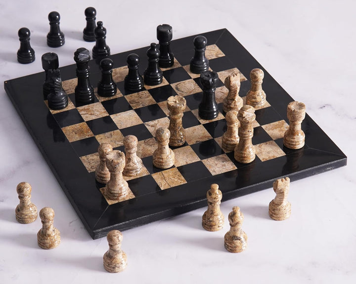 Marble chess set with black and beige pieces on a white background